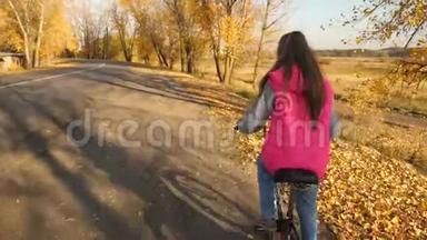 十几岁的女孩在公园里学骑自行车。 女孩的手拿着弯曲的车把。